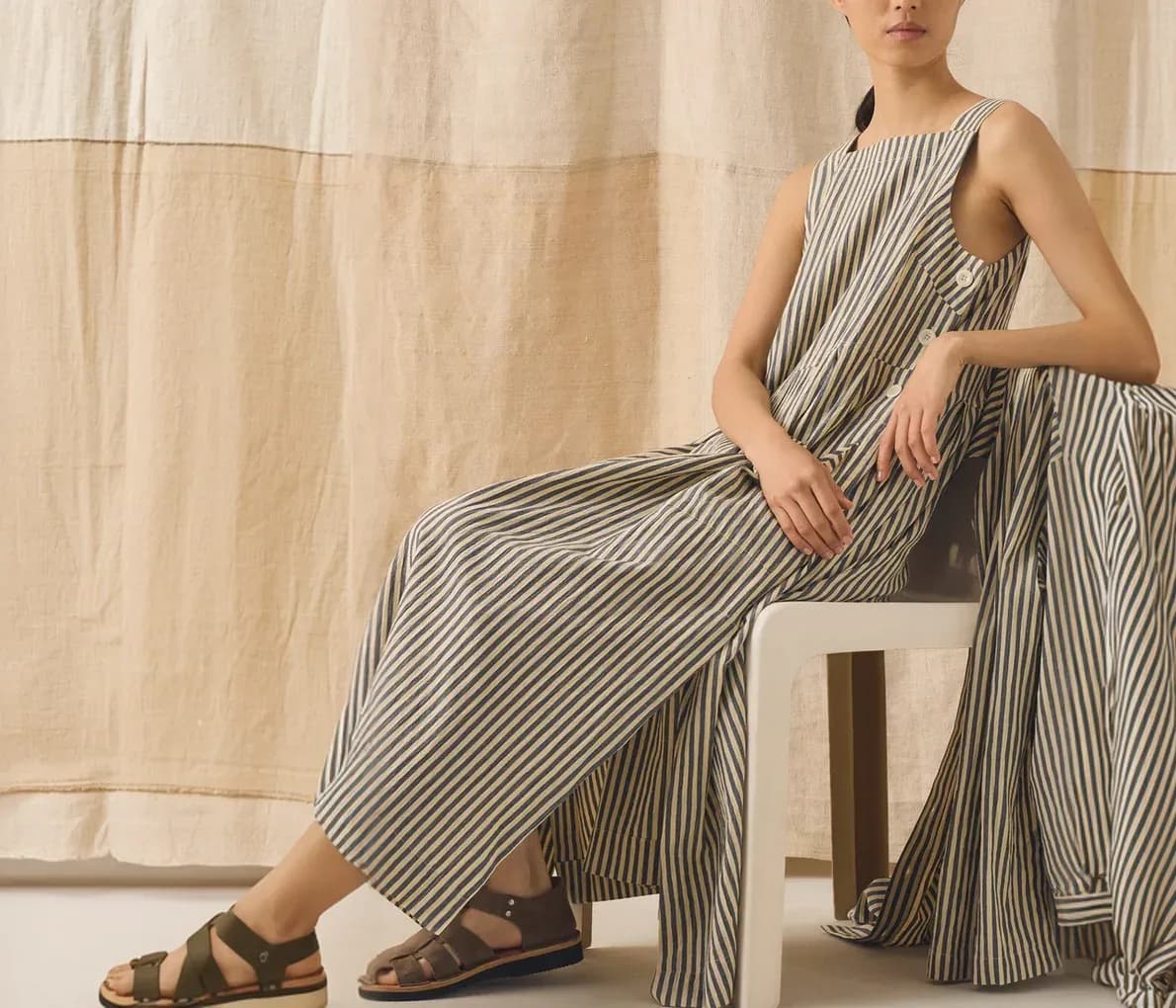 Model wearing a striped linen jumpsuit